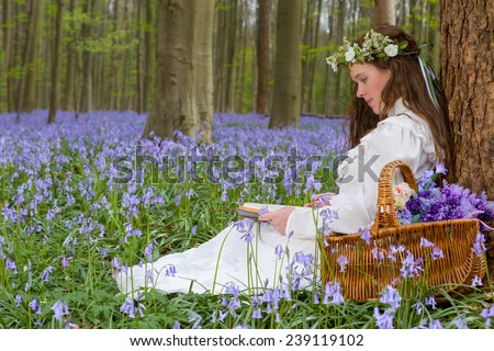 Victorian woman in white dress in a springtime bluebells forest