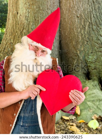 Romantic garden gnome showing a red heart