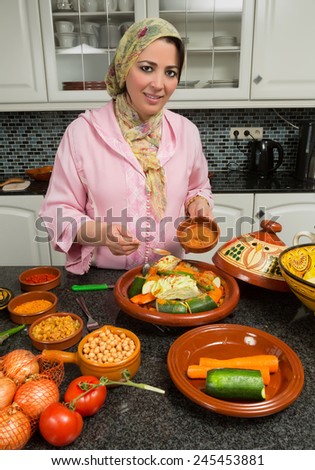 Moroccan immigrant woman in modern European kitchen preparing traditional tajine dish for Ramadan nights