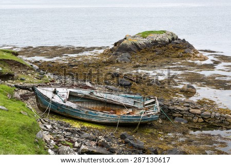 Weathered fishing boat lying on a rocky beach on the Isle of Lewis, Outer Hebrides, Scotland