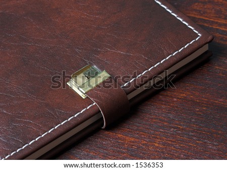 Personal diary in leather, on a wooden background