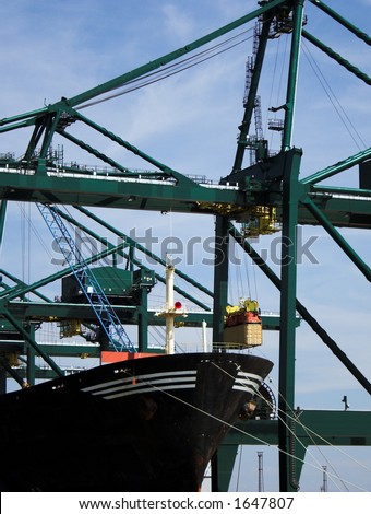 Container being transferred into a cargo ship at Antwerp harbor (brand names and logos have been removed)