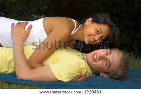 Young couple making love on a beach towel