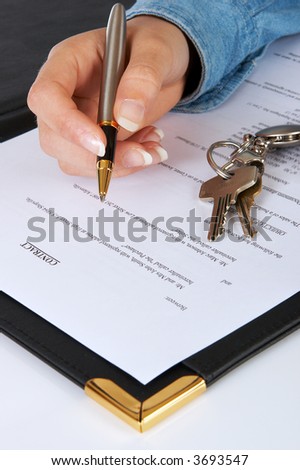 Hand and pen signing the contract for a new home - the text of the contract is purely fictitious