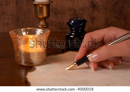 Hand writing on parchment with a golden fountain pen