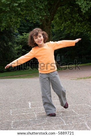 Little girl playing hopscotch in the local park