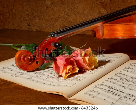 Vintage still life with a violin, music book and soft roses