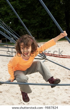 Little girl on a climbing frame at the playground