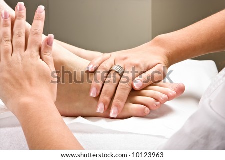 Woman\'s hands giving a healthy foot massage