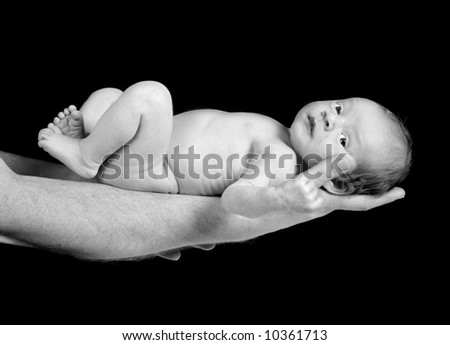 Father holding his 15 days old son on his arm