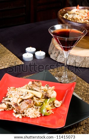 Beautiful table setting with pilaf rice and red wine