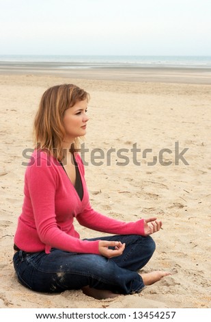 Young woman doing morning meditation on the beach