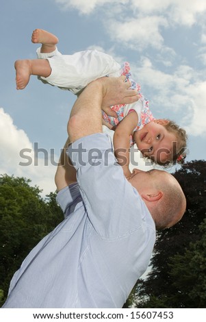 Older father playing with his little girl in the park