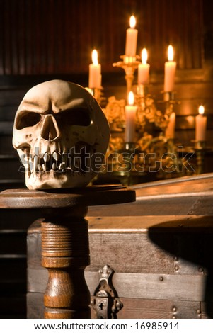 Spooky skull lit by candles in gothic surroundings