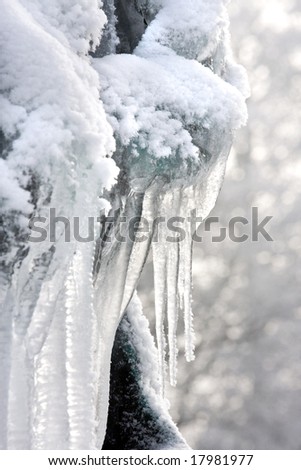 Freezing winter sculpture of white icicles covered in snow