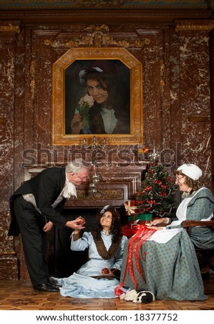 Vintage Christmas scene of a Victorian family decorating a Christmas tree. Shot in castle \