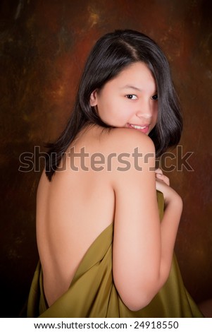 Young beautiful woman covering herself with a silk scarf