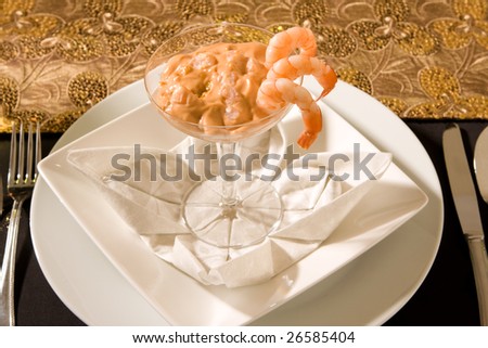 Festive dinner setting with shrimp cocktails and white wine