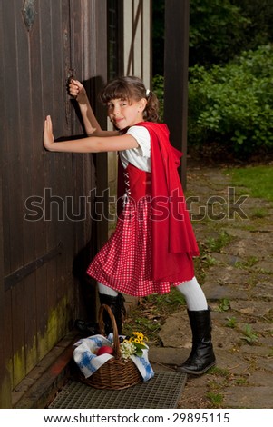Little red riding hood entering the cottage of her grandmother