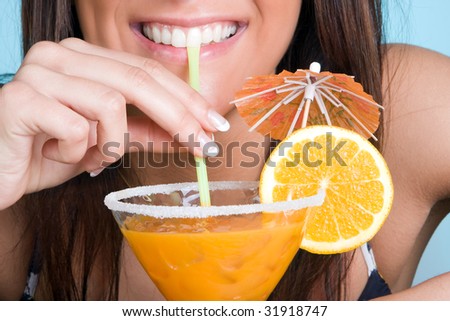 Closeup of a young woman drinking an orange cocktail