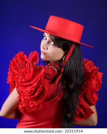 Young Spanish flamenco dancer posing in a red dress and hat