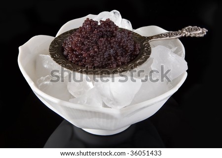 stock photo : Black caviar served on ice in a silver plate