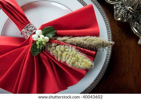 Festive red decorated napkin with ornate sterling silver napkin ring