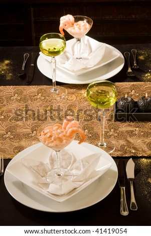 Festive dinner setting with shrimp cocktails and white wine