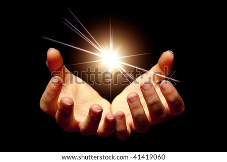 Female hands holding a brilliant star in the dark