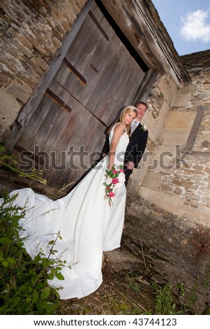 Young wedding couple against a grunge medieval wall