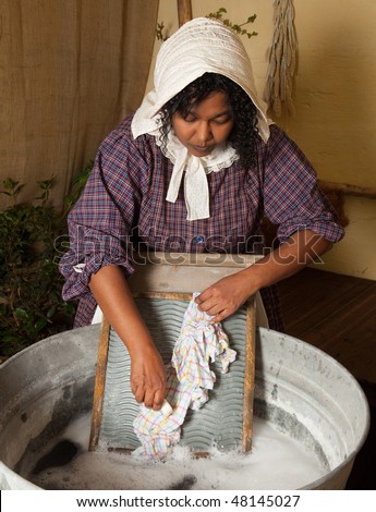 Victorian woman washing laundry with an antique washboard