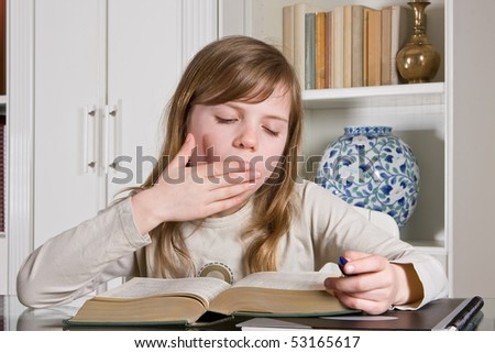 Young teenager girl studying a boring lesson