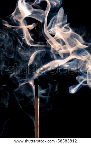 Single match stick being blown out with a wisp of smoke
