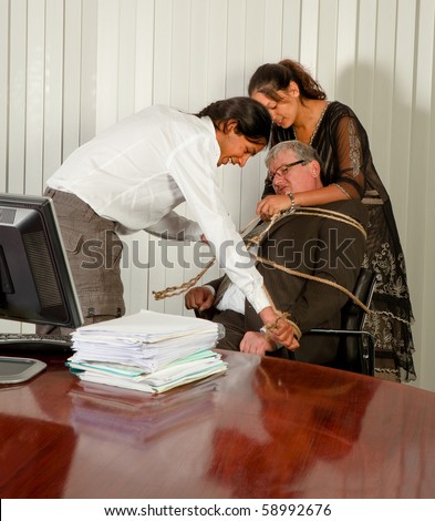 Employees tying the office manager to his chair with a rope