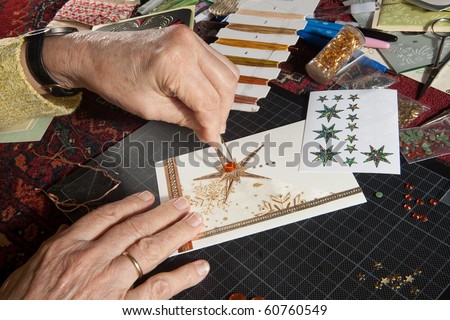 Hands of a woman crafting and scrap-booking christmas cards