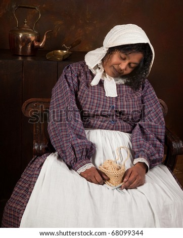 Reenactment scene of a victorian woman sleeping in an antique vintage kitchen