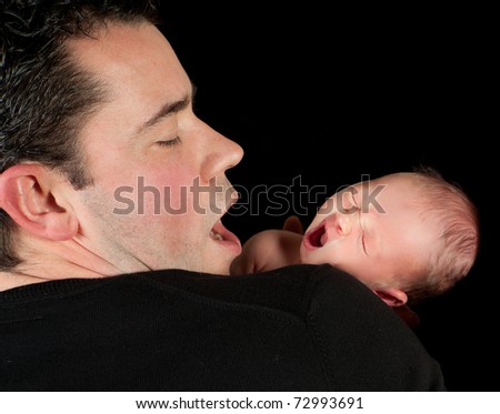 Yawning father with his 18 days old baby
