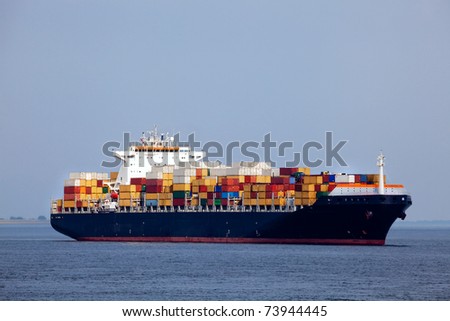 Huge container ship passing - all brand names removed from every container