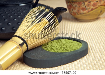 Closeup of green powder tea with teapot and bamboo whisk for zen ceremony