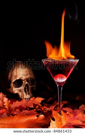 Burning halloween cocktail with skull and glass eye