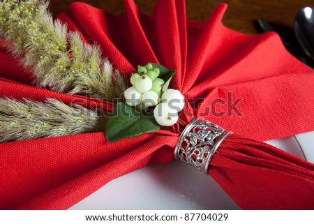 Festive red decorated napkin with ornate sterling silver napkin ring