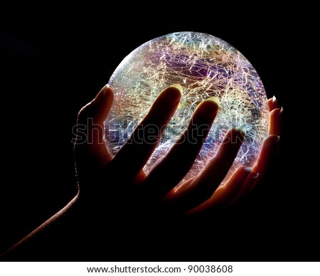 Hands holding a glowing colorfull glass or crystal ball