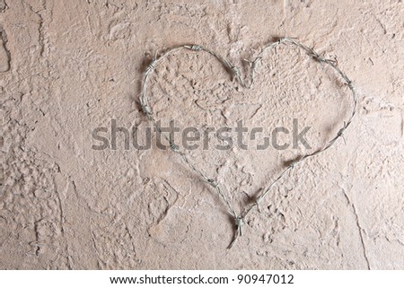 Barbed wire bent into a heart shape on a grunge background