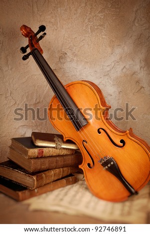 Old classical violin with antique books and grungy sheet music