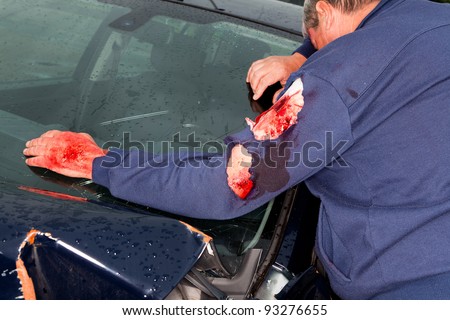 Injured man standing next to his wrecked car after a car accident