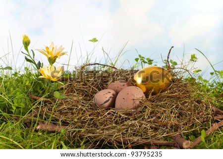 Golden easter egg in a nest with ordinary brown eggs