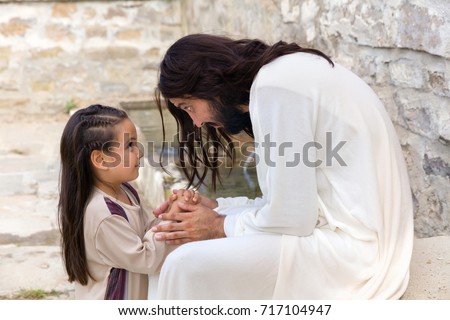 Biblical scene when Jesus says, let the little children come to me, blessing a little girl. Historical reenactment at an old water well.