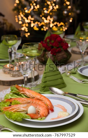 Festive dinner table with flower arrangements and decor napkins and christmas tree in the background