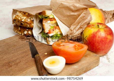 Fruit, sandwiches and buns in a brown paper lunch bag