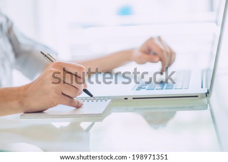 Businesswoman writing report at office